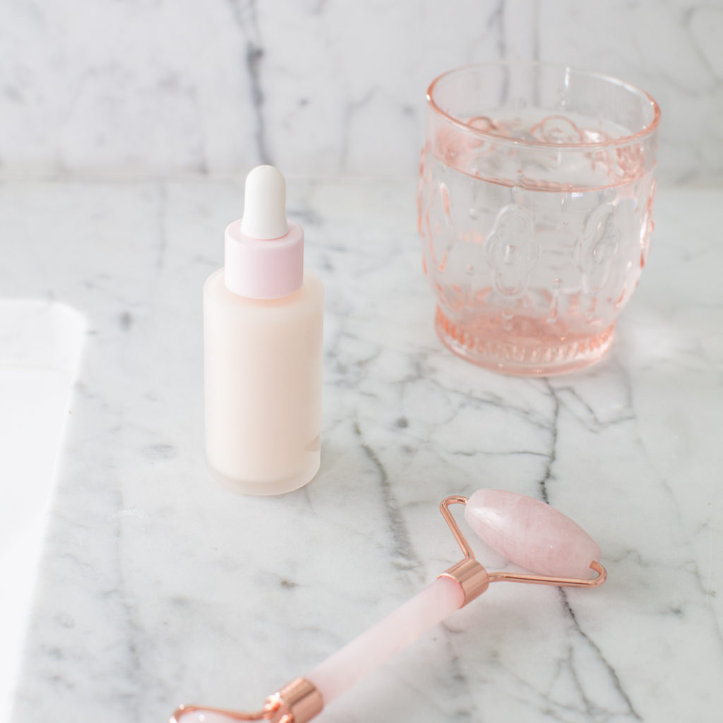 a face roller and a bottle of serum